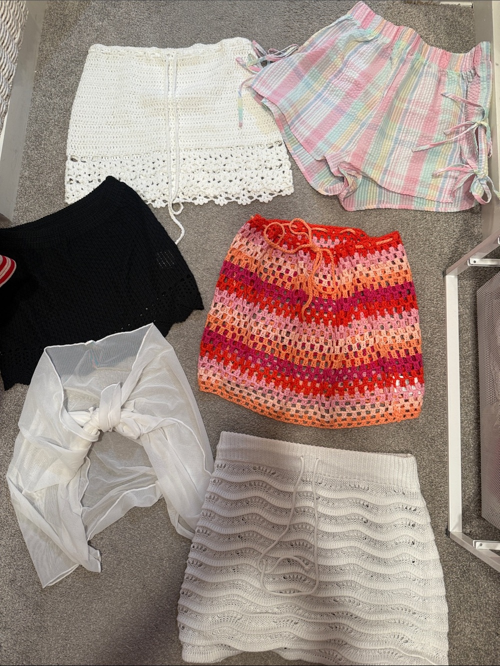 Assortment of different crochet cover up skirts and shorts
